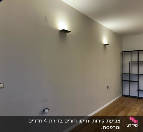 קיר צבוע עם תאורה עליונה ומדף מתכת